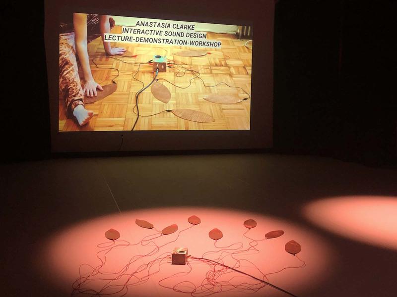 a spotlit stage withsound devices spread across the floor 