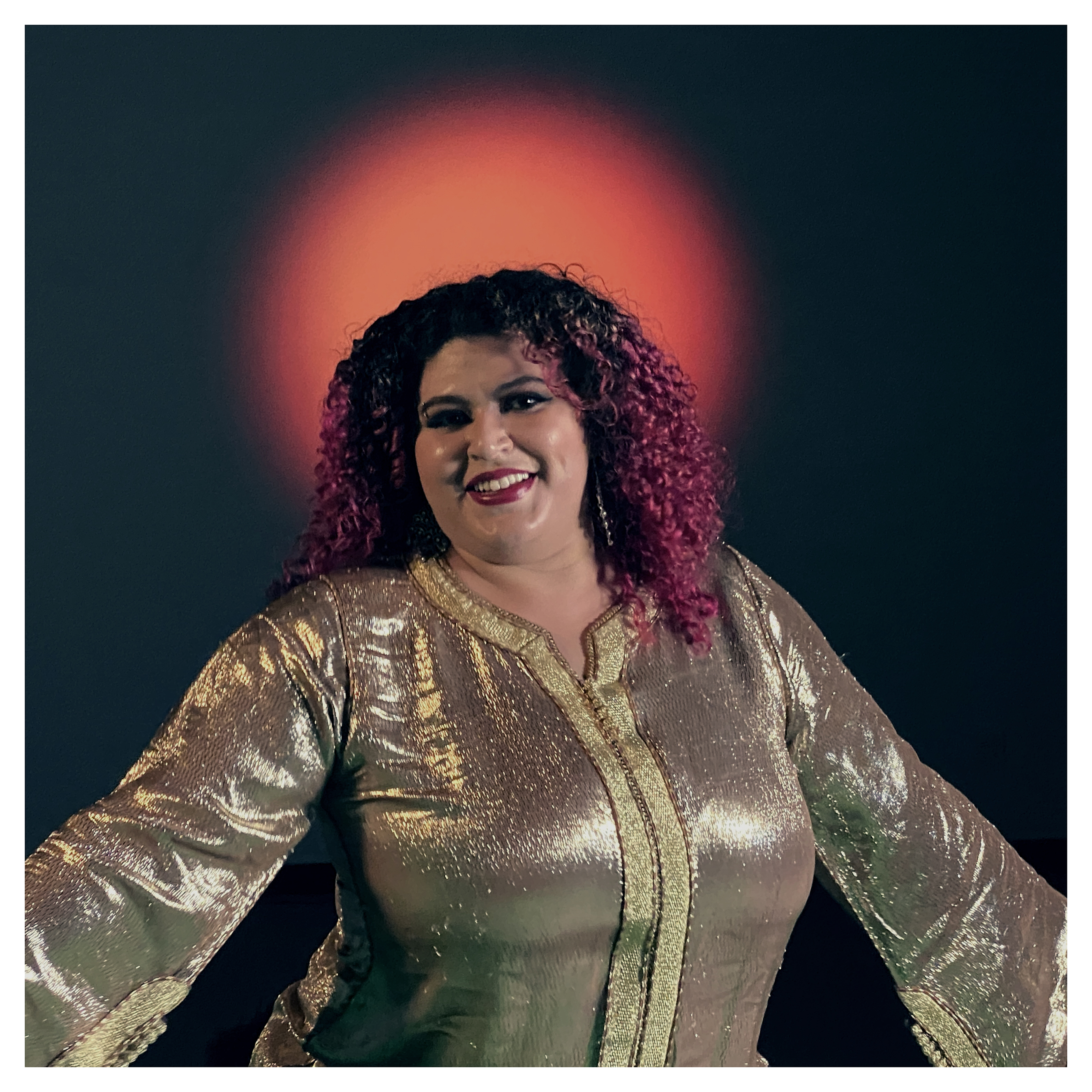 Esraa Warda in the Movement Lab in gold dress and red circular light behind her. Photo by Guy de Lancey