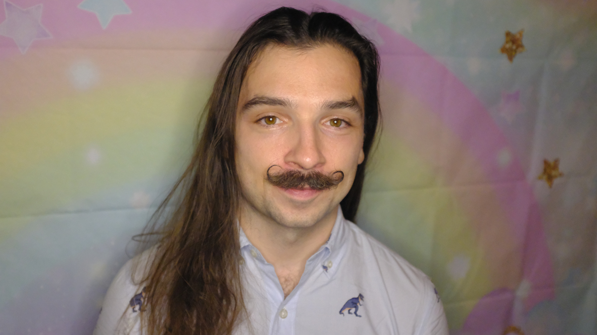 A headshot of Collin Kelly against a rainbow background