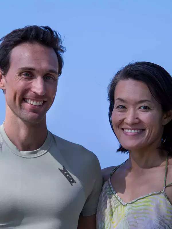 Chisa and Ben smile under a blue sky